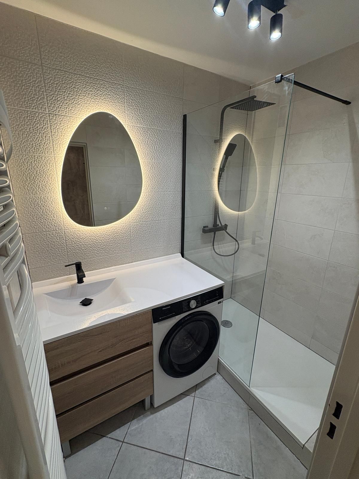 Après : salle de bain neuve avec faïence, miroirs lumineux et douche vitrée